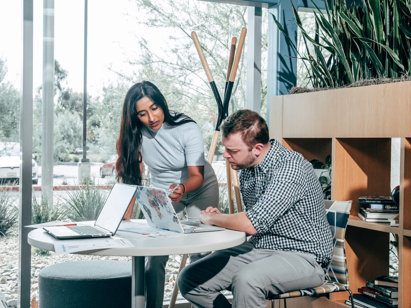 Two colleagues discussing work together at a laptop
